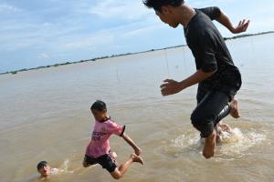 Trẻ em vùng giáp ranh biên giới Việt Nam - Campuchia nô giỡn trên cánh đồng nước lũ